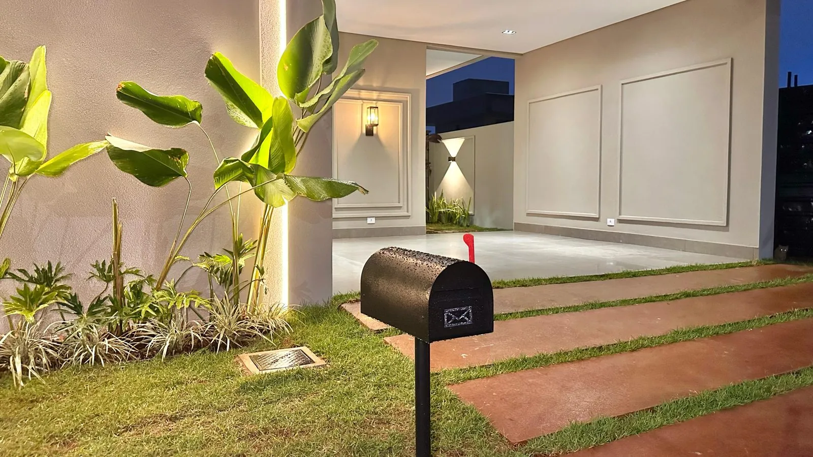 Jardim frontal da Residência Ramos com pisantes ao entardecer
