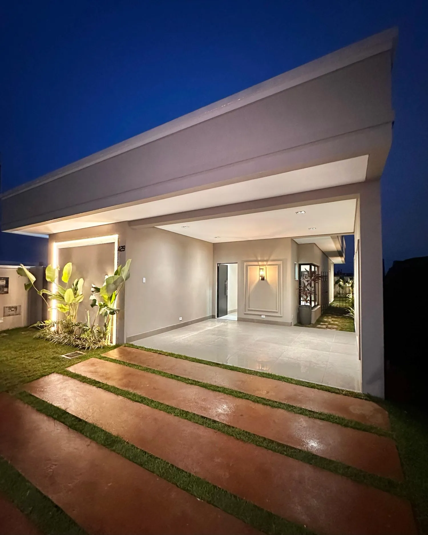 Entrada coberta da Residência Ramos iluminada à noite